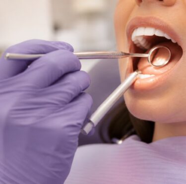 Dentist performing a careful oral cancer screening during a routine dental examination